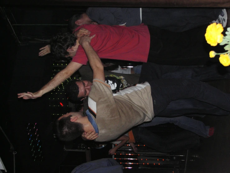 three men with one holding another up in the air