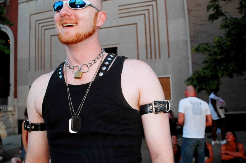 a man in a black tank top and his necklace is smiling