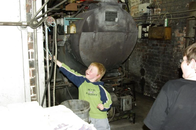 two people in a room with a huge metal object