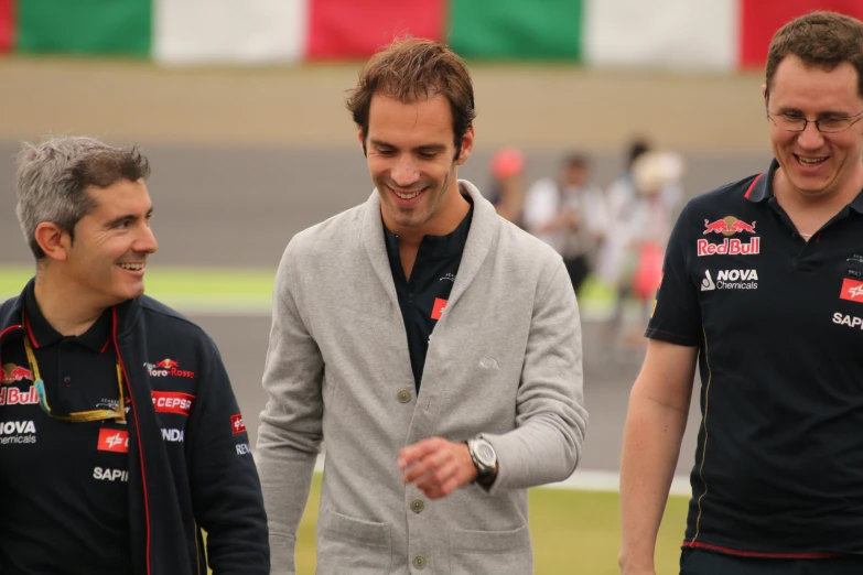 the men are talking on a racing track