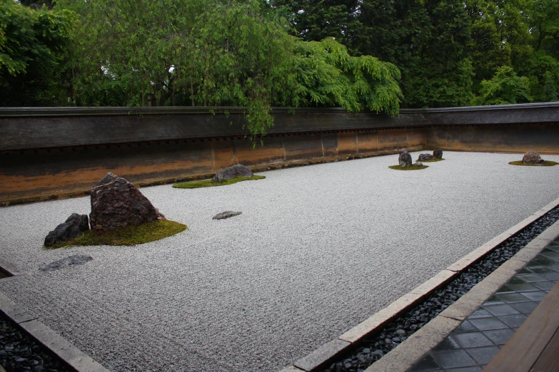 a stone garden with a rock and moss on it