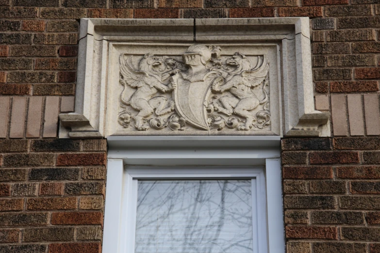 a brick building with a stone ornamental seal on the front of it