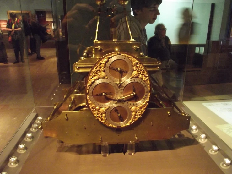 an ornate clock set in glass in a display case