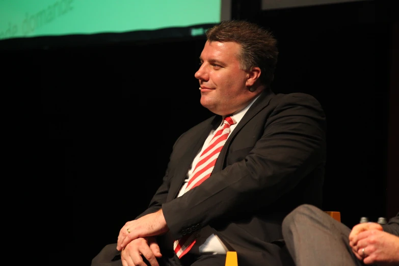 a man is seated with his arms crossed