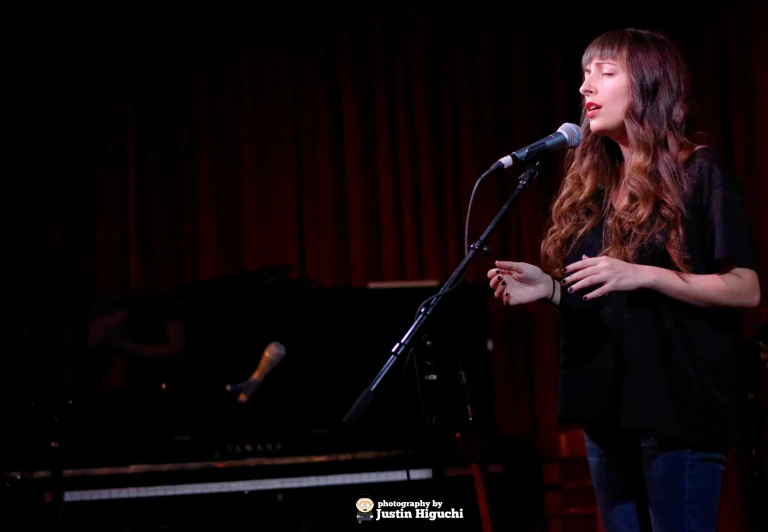 a person standing up with a microphone in front of a stage