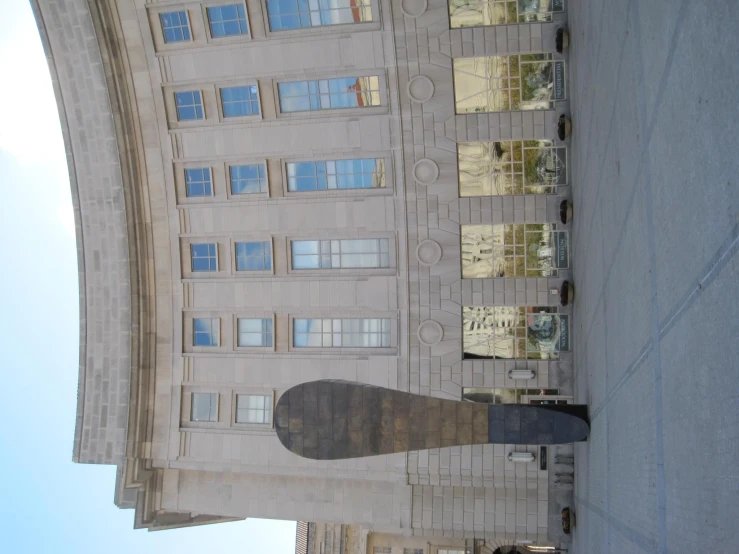 a large building with a giant black sculpture in front