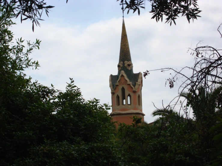 a small brick clock tower towering over trees