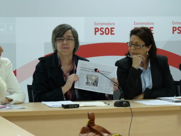 four women sitting at a table in front of the microphone