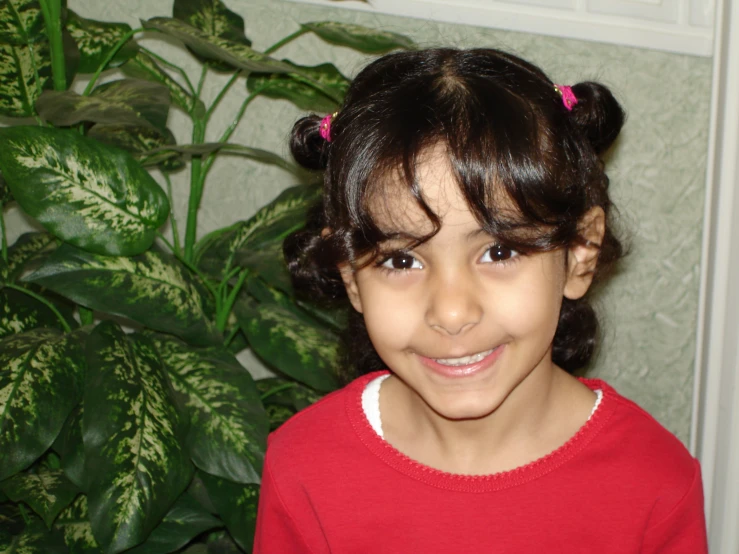  smiling at camera by potted plant