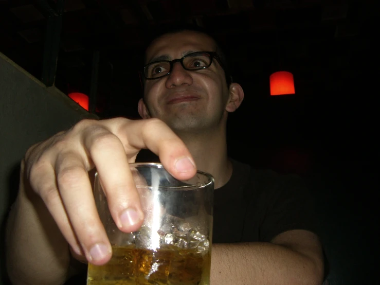 a person in glasses holding onto a drink