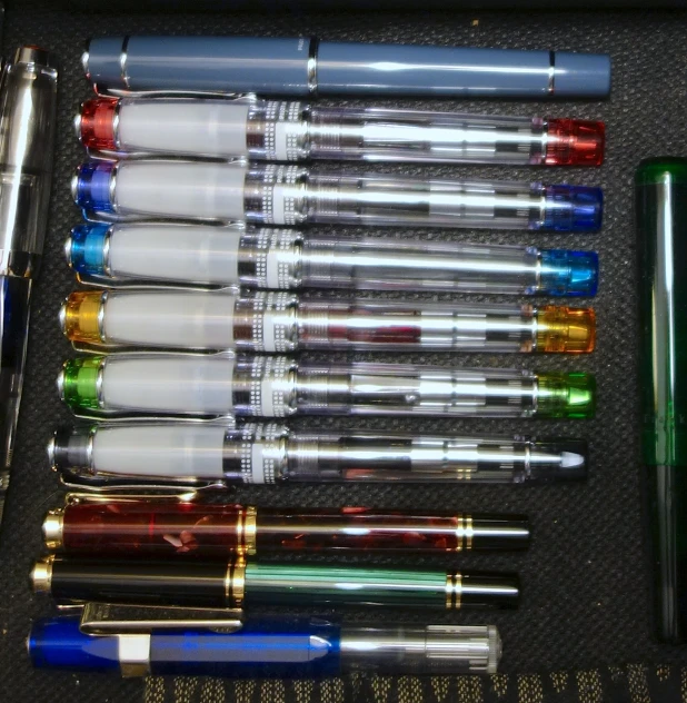 a set of nine fountain pens, various types, are displayed