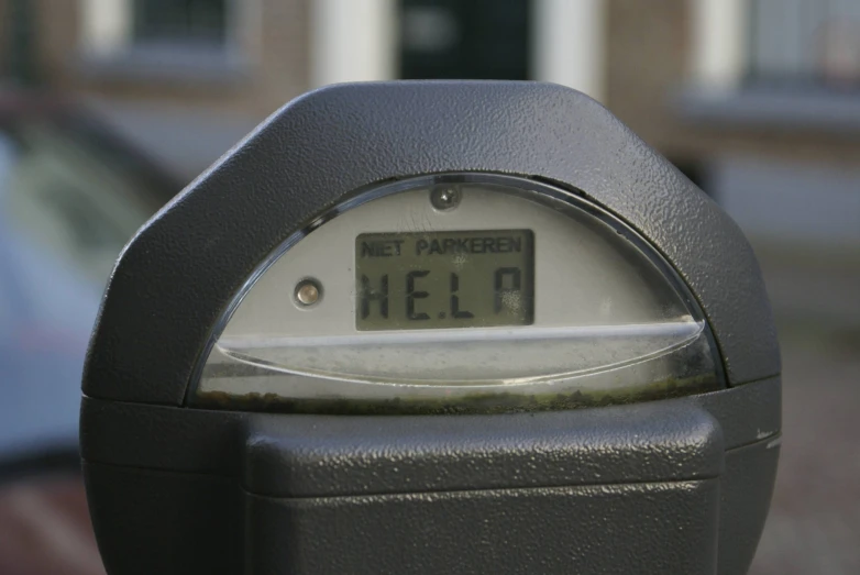 a close up of a parking meter with a building in the background