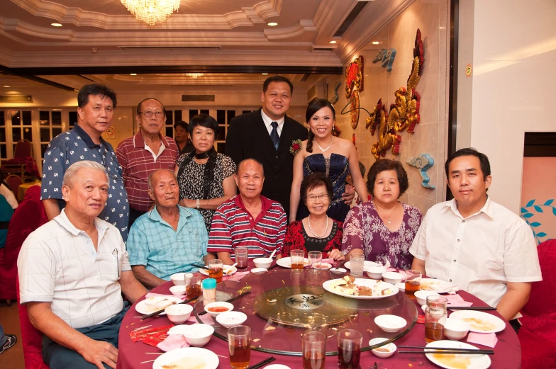 the family is posing for a group po at the dining table