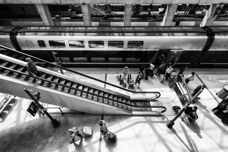 some people standing around with luggage and a train in the background