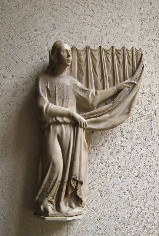 a statue standing on a white ledge next to a wall