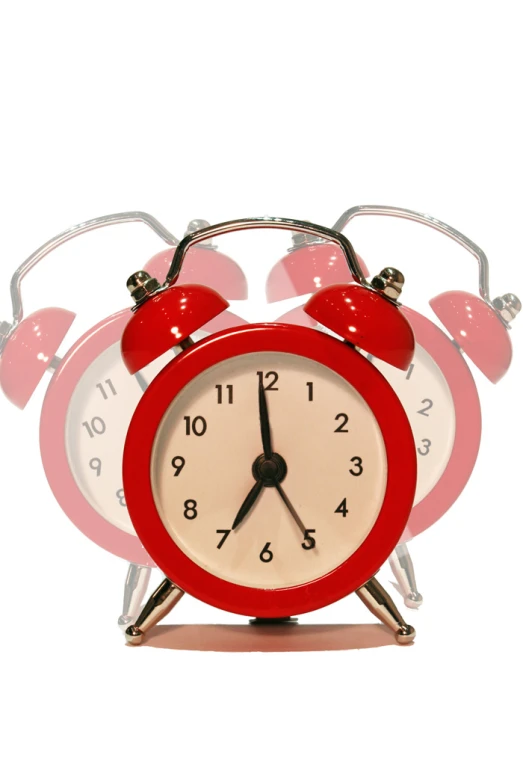 a red alarm clock sitting on top of two other clocks