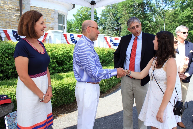 there is a woman shaking hands with two men