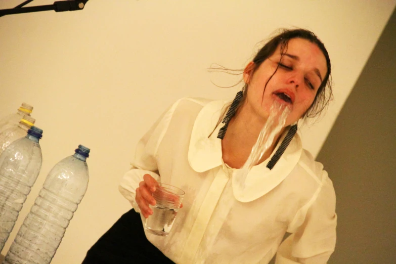 woman covered in plastic strips and drinks water