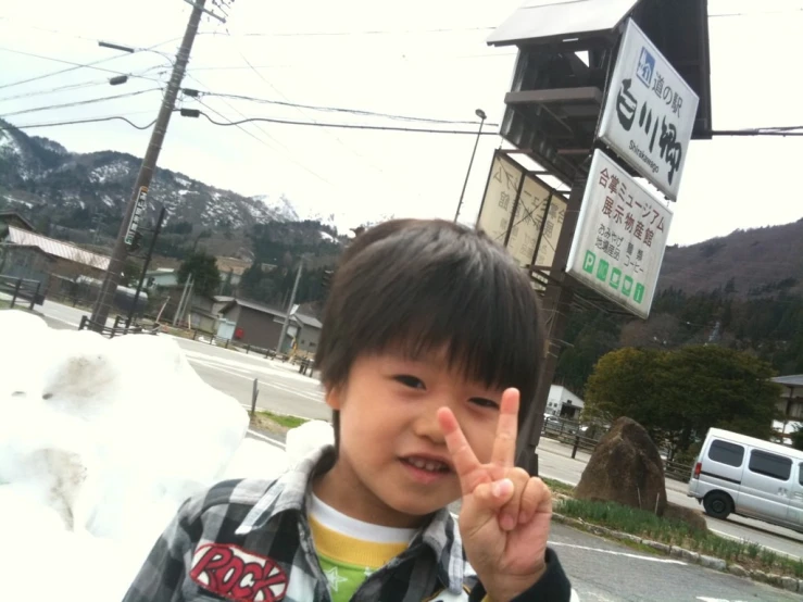 a  holding a peace sign outside