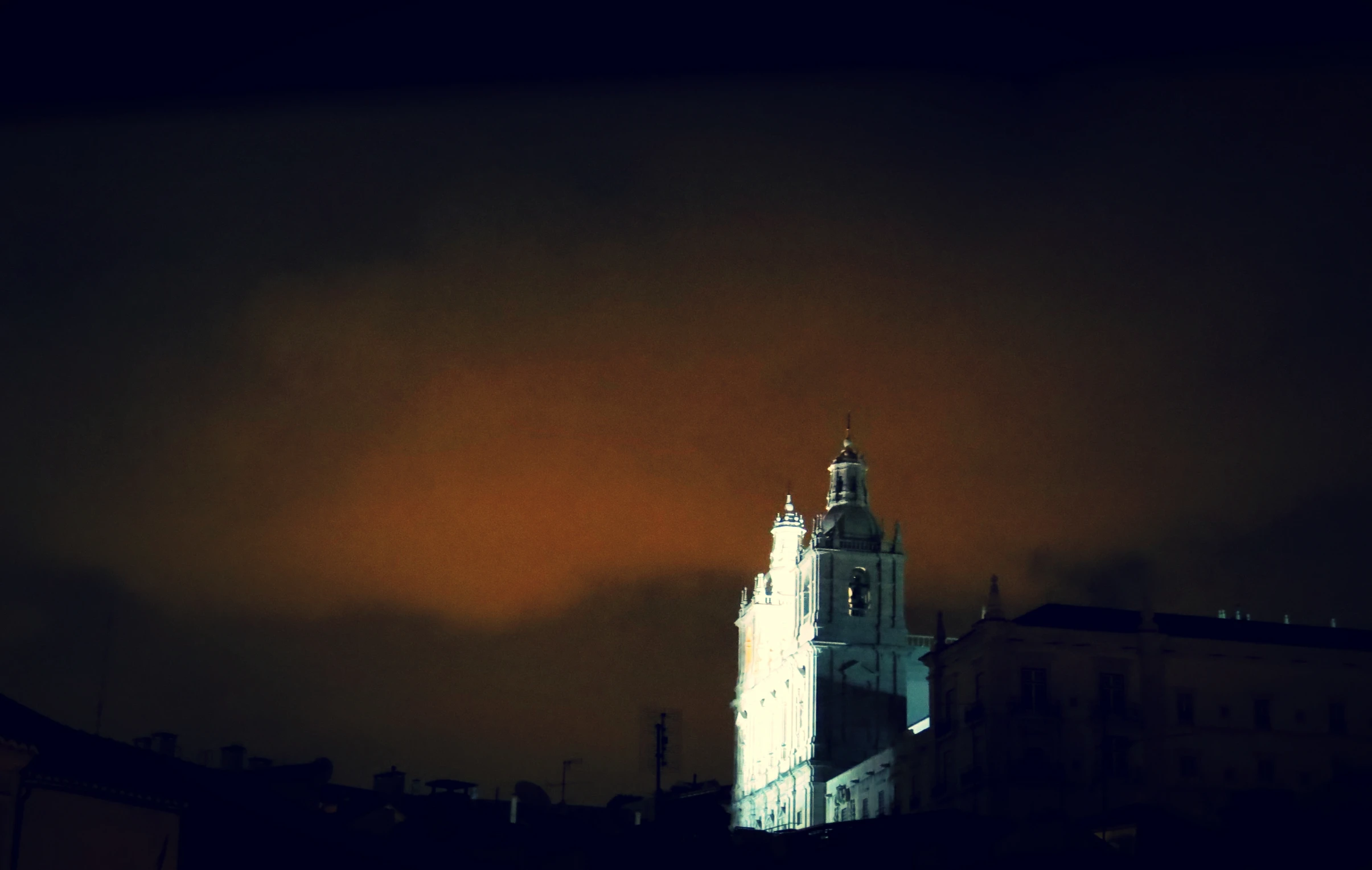 a large clock tower in the dark with a sky background