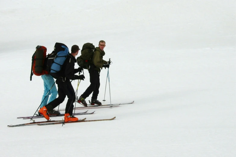 three cross country skiers with their gear on