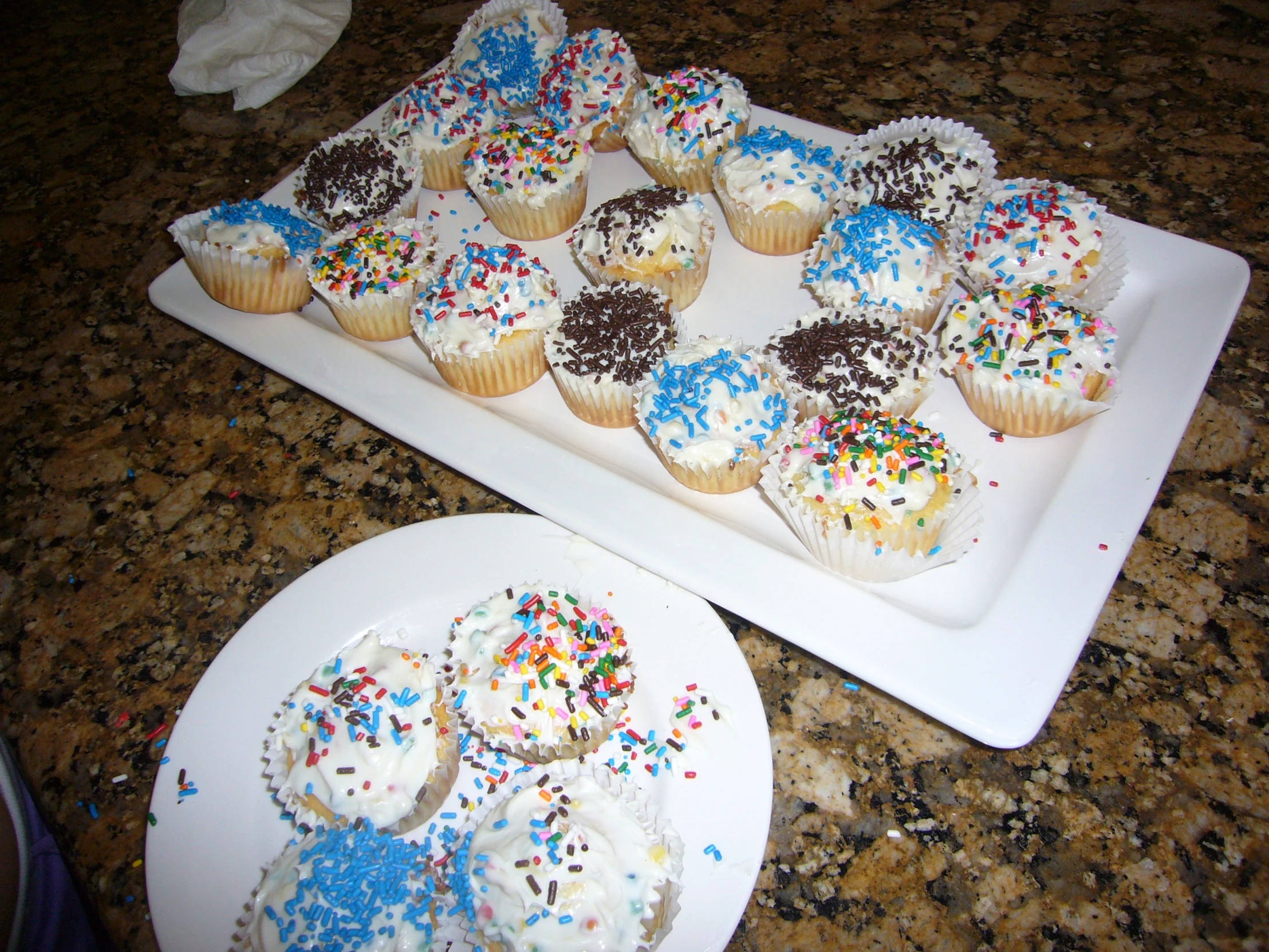 a plate of donuts and a cupcake on a counter