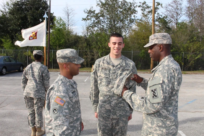 two men are shaking hands near three other men in the parking lot