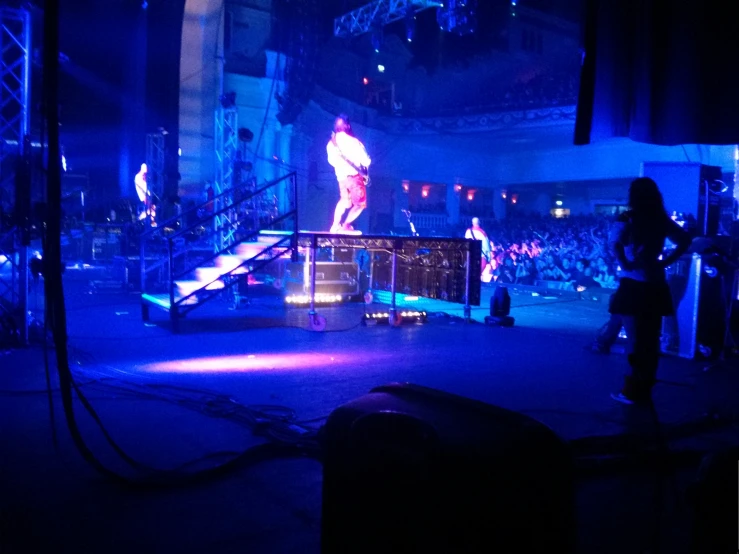 an illuminated stage that has people standing on it