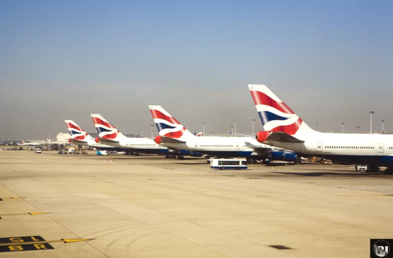 four airplanes are parked on a runway next to each other