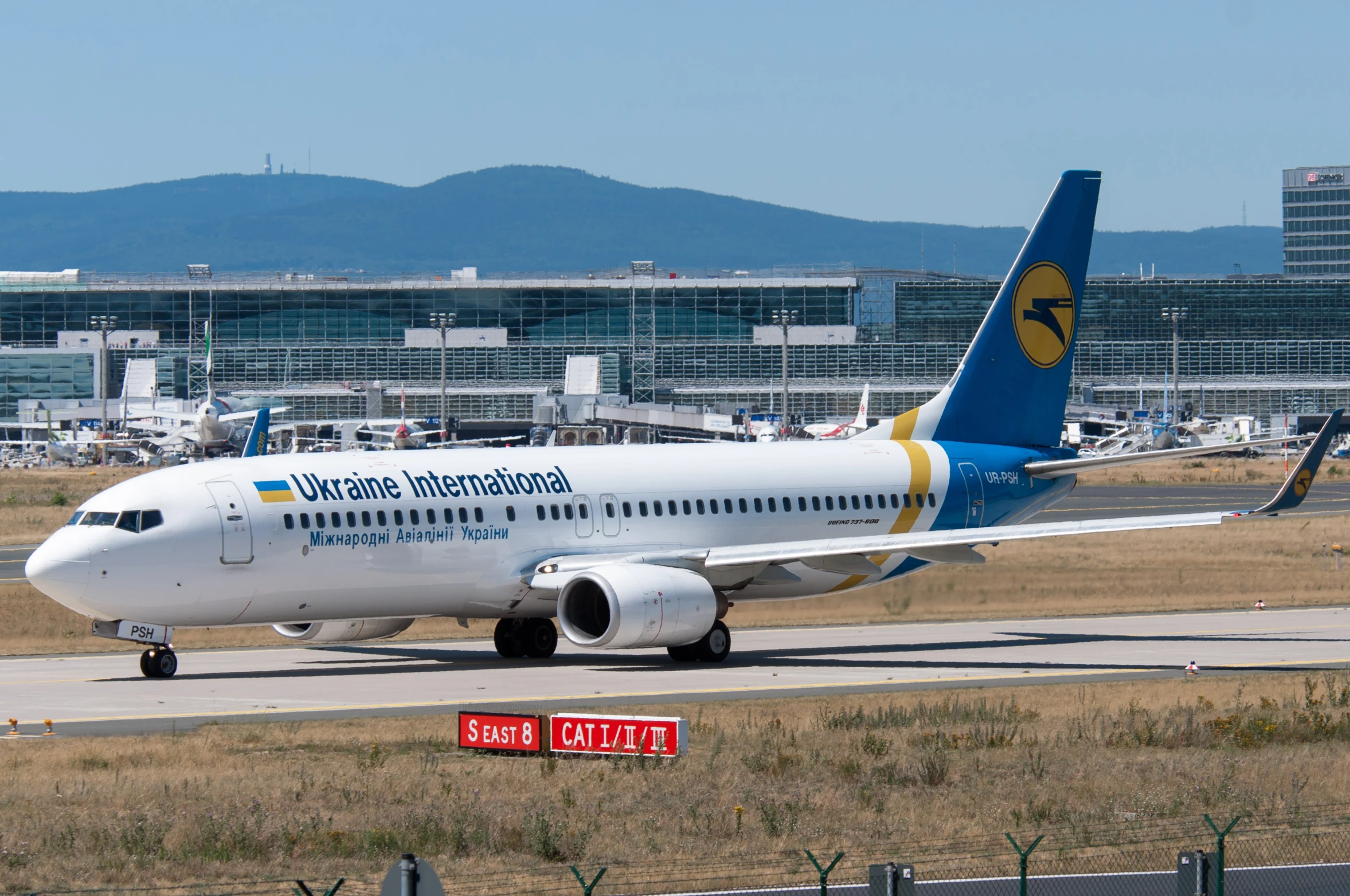 a plane is sitting on the tarmac in a large airport