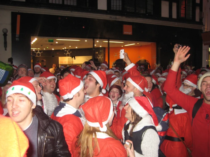 a group of people with santa hats are gathered around