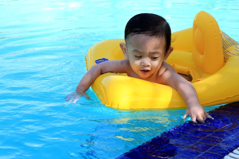 a boy in the pool on an inflatable raft