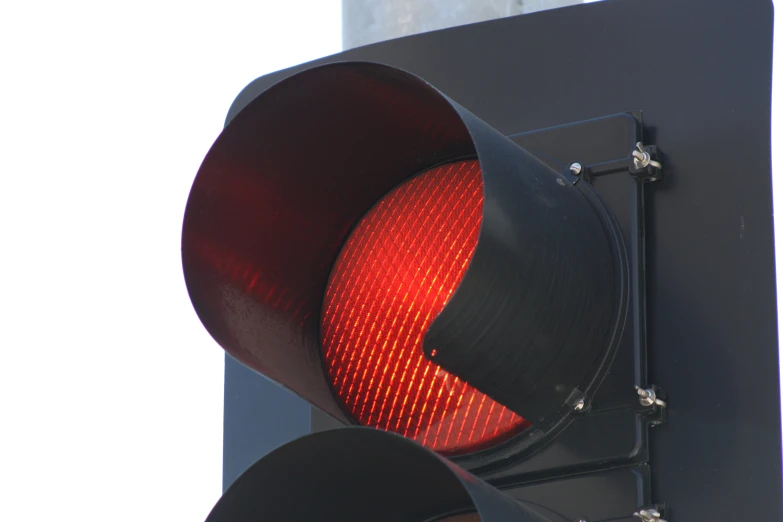 a red stop light is attached to a pole