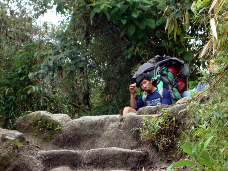 people sit at the edge of some steps in the jungle
