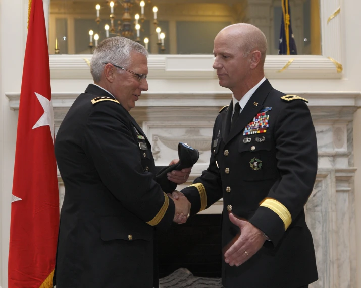 two military officers shaking hands during a ceremony