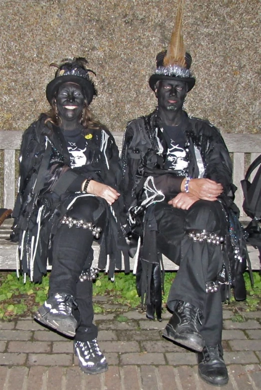 two people in costumes sit on a bench