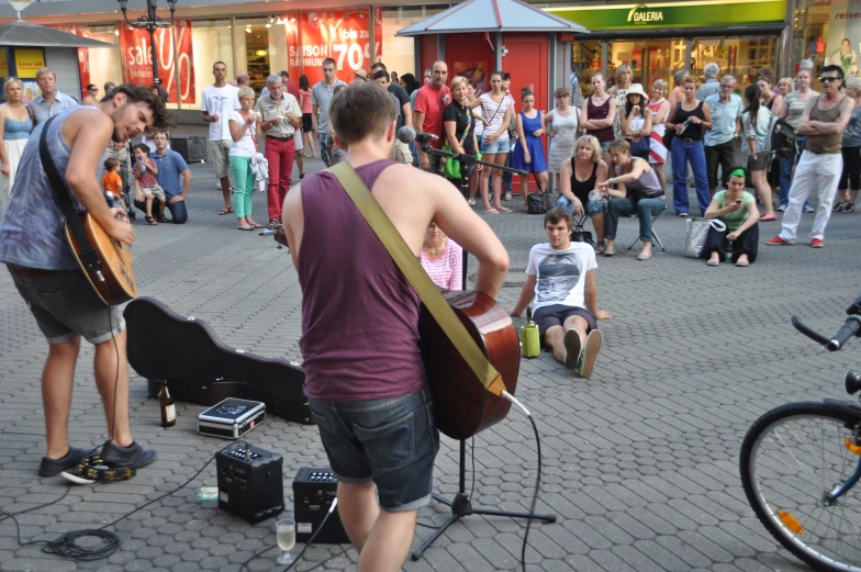 a man plays a guitar as people play music