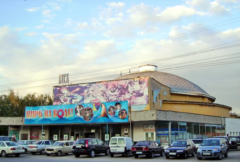 many cars are parked on the road in front of the theater