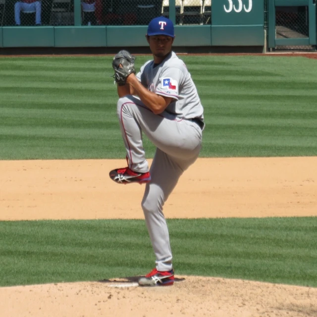 a baseball player pitching a baseball on top of a field