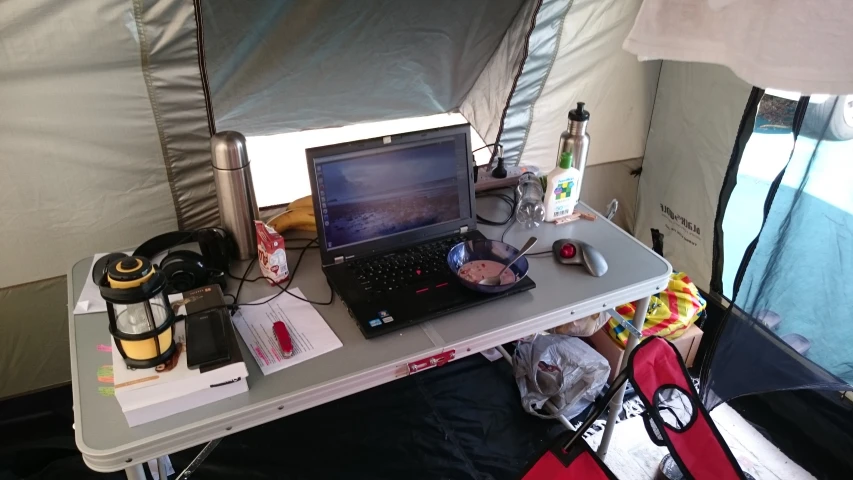 a laptop on a table near a tent