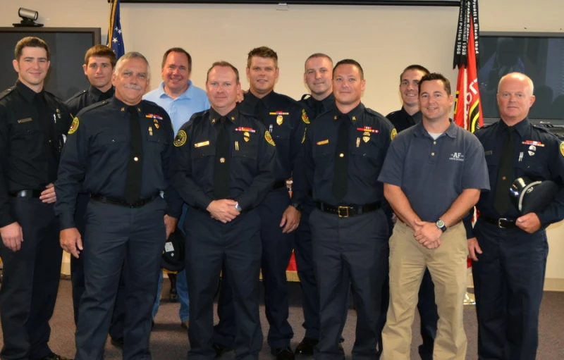 officers posing for a group picture with flags