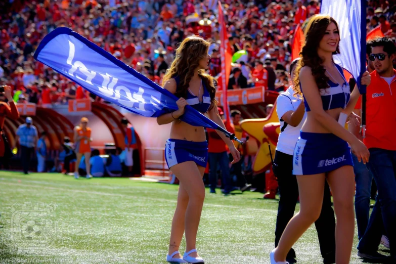 two cheerleader in the process of dancing on a field