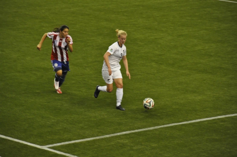 two female soccer players on field during match play