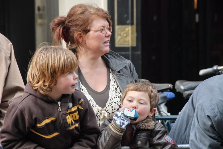 woman and two boys with their drinks near some parked motorcycles