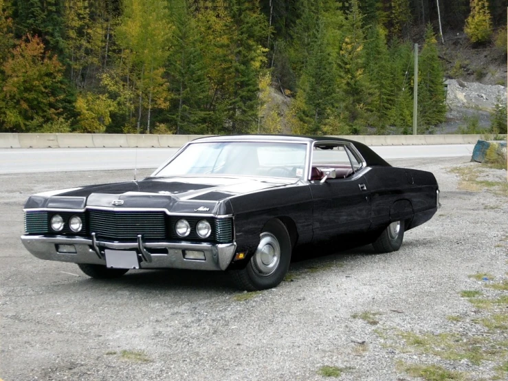 a classic black car parked in a parking lot