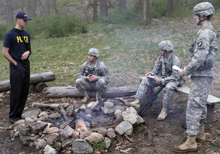 military officers standing around a fire pit on the ground