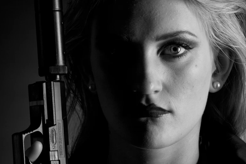 a woman with a gun in the darkness