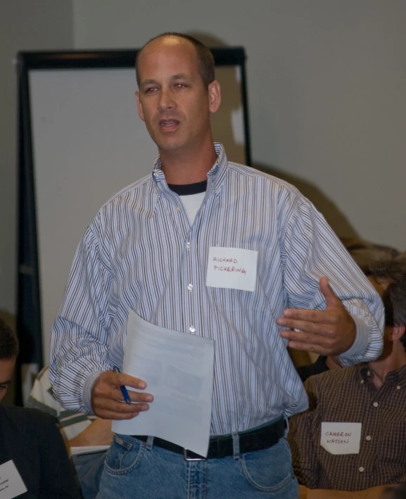 a man with a paper in his hand standing