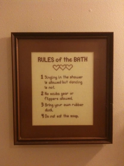 a framed sign on the wall says rules of the bath