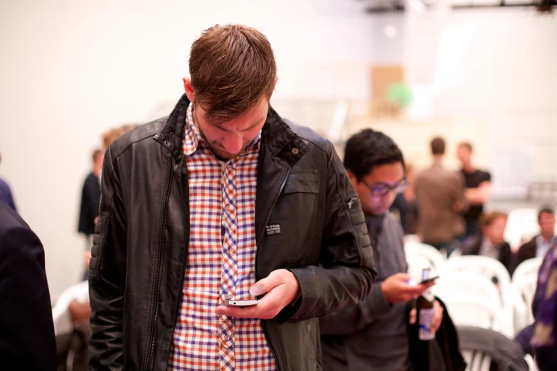 a man is checking his cell phone in the crowd